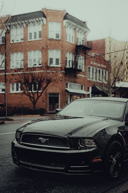 Luxury Cars - Modern black car parked on a rainy urban street #34998665